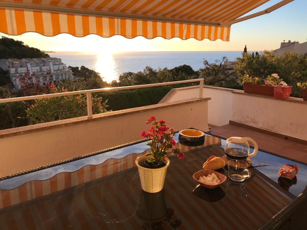 a table on a balcony with a view of the ocean at Apartamento con piscina - Tossa - Magníficas vistas al mar in Girona