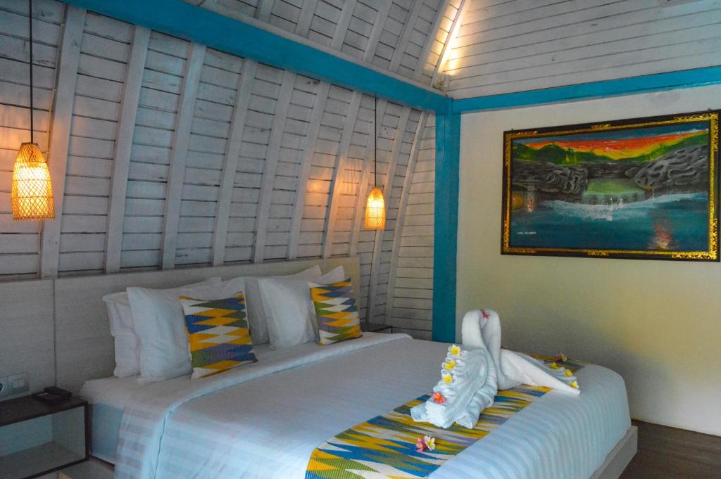 Un dormitorio con una cama con dos cisnes. en The MG Villa & SPA, en Nusa Penida