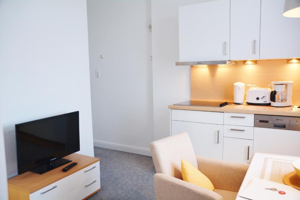 a kitchen with a couch and a tv in a room at Ferienhaus Pauls Ferienhaus Pauls, Whg 10 in Norderney