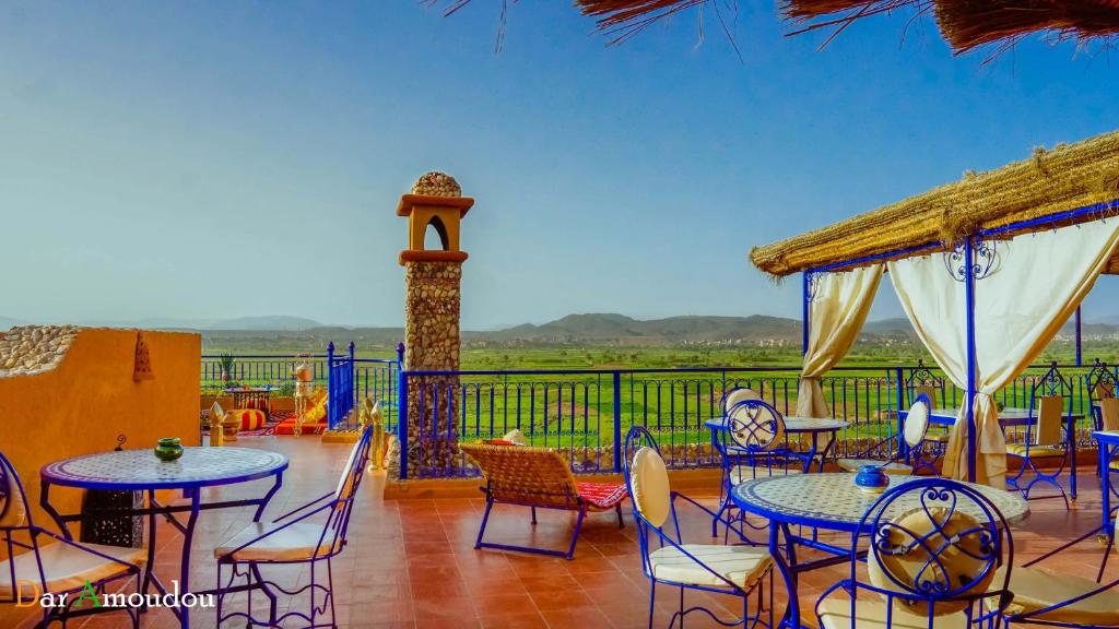 a patio with tables and chairs and a clock tower at Dar Amoudou in Ouarzazate
