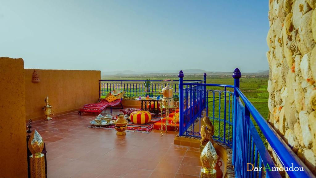 a balcony with a blue railing and a living room at Dar Amoudou in Ouarzazate