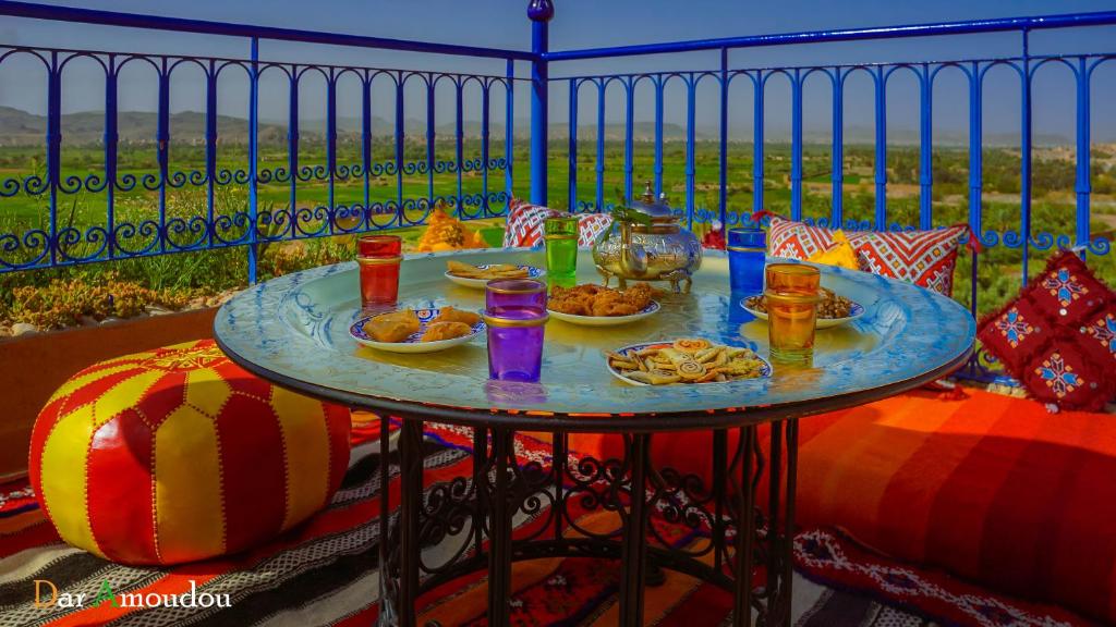 a table with plates of food on a balcony at Dar Amoudou in Ouarzazate