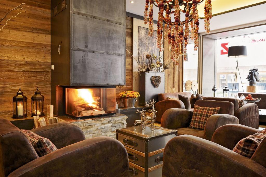 サンモリッツにあるホテル ピッツ サン モリッツのリビングルーム(暖炉、革張りの椅子付)