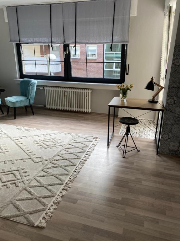 a living room with a table and a rug at Buer City Apartment mit Balkon in Gelsenkirchen