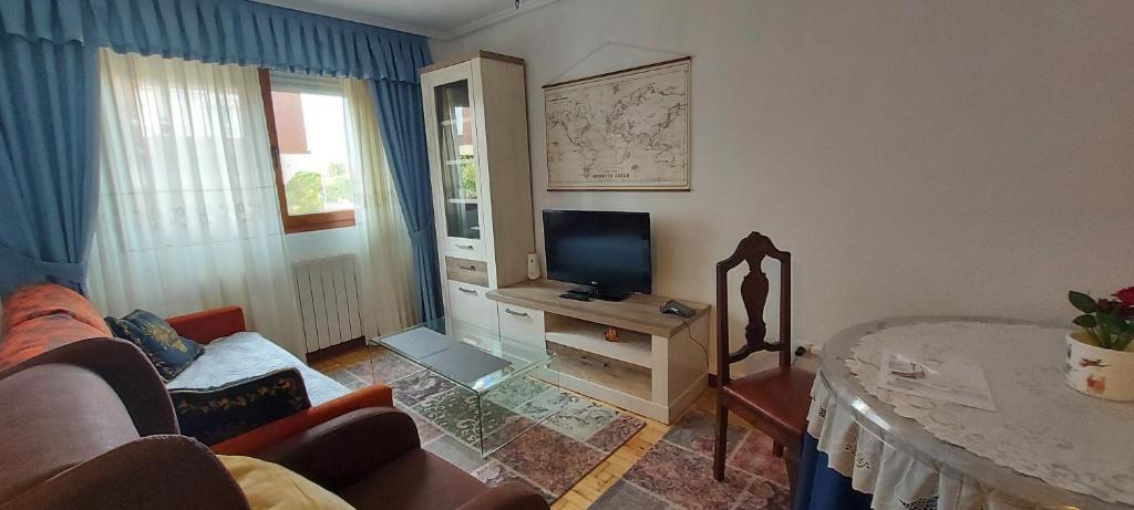 sala de estar con sofá y TV en Apartamento Sobrevilla SDR IV, en Santander