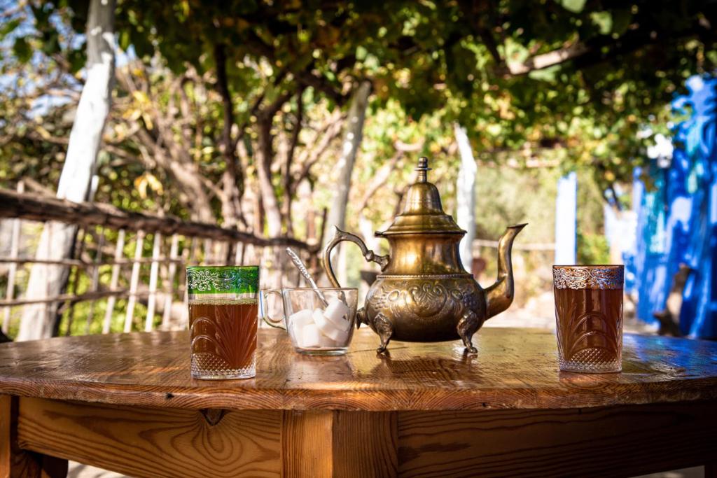 un tavolo con bollitore per il tè e 3 bicchieri sopra di Blue House Town a Chefchaouen