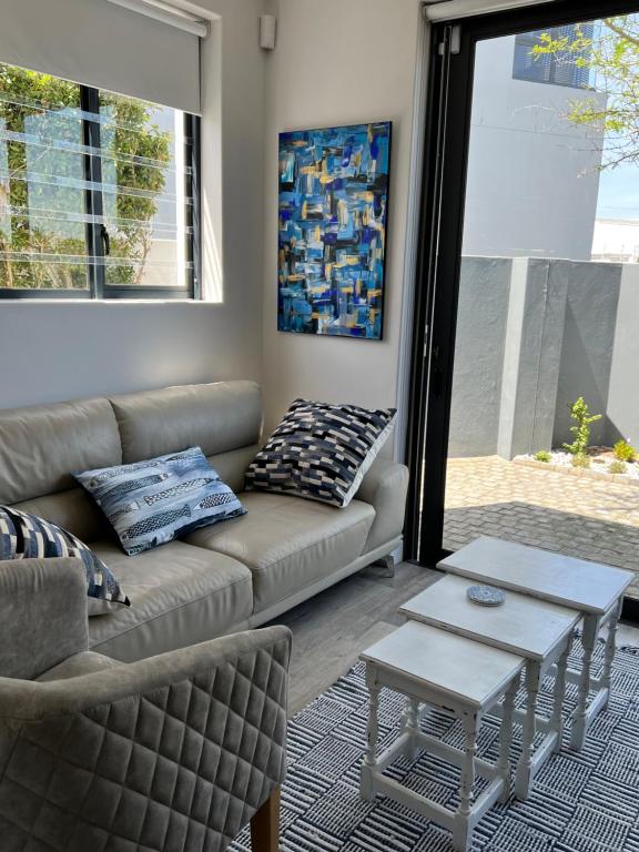 a living room with a couch and a table at Cowrie Cottage Self Catering in Cape Town