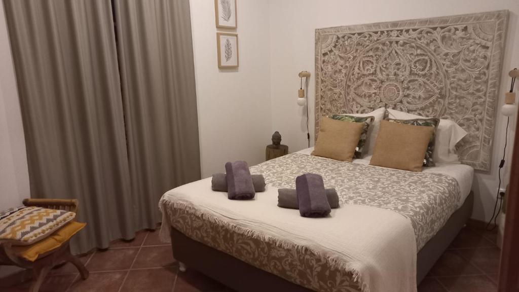 a bedroom with a bed with two towels on it at House Bali Furnas in Furnas