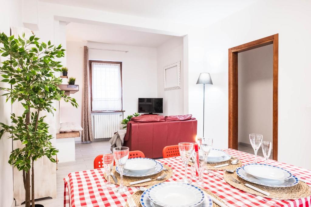 uma mesa de jantar com uma toalha de mesa vermelha e branca em Casa Dolce Casa Desenzano - 2 passi dal lago em Desenzano del Garda