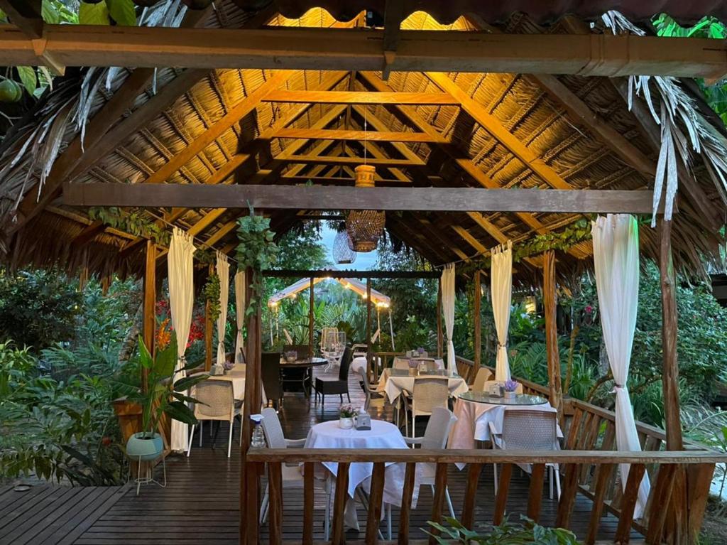 un restaurante con mesas y sillas en una terraza de madera en Hotel Madreselva, en Leticia