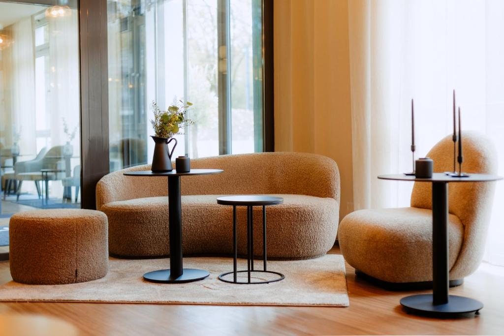 ein Wohnzimmer mit 2 Tischen und einem Stuhl in der Unterkunft Moods Hotel Dortmund in Dortmund