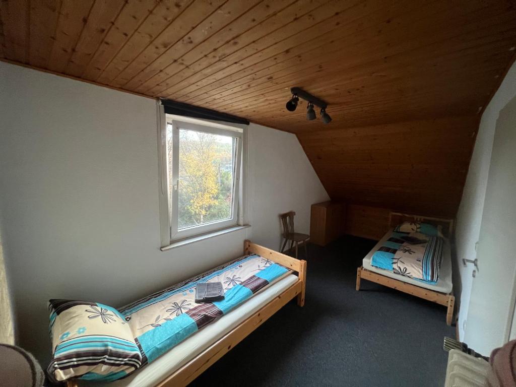 1 dormitorio con 2 camas y ventana en Siegen Achenbach 4, en Siegen