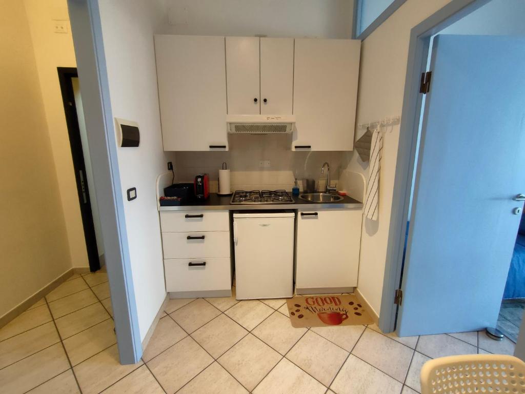 eine Küche mit weißen Schränken und einer Schachtel auf dem Boden in der Unterkunft Le Tre Palme in Ancona