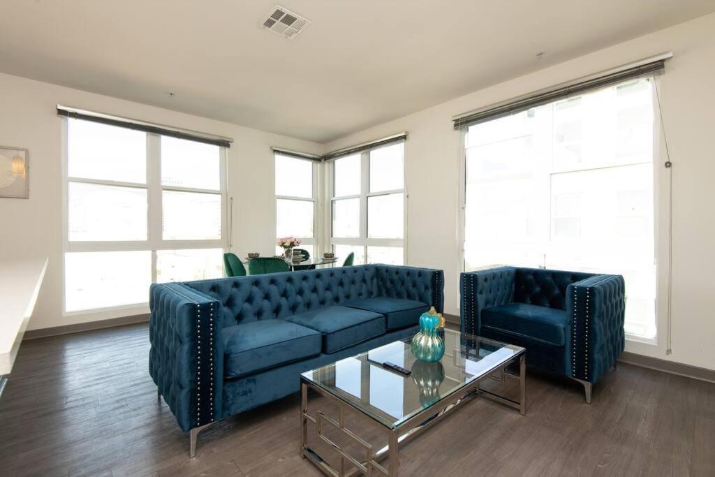 a living room with two blue couches and a table at Centrally Located Apartments with Free parking in Glendale