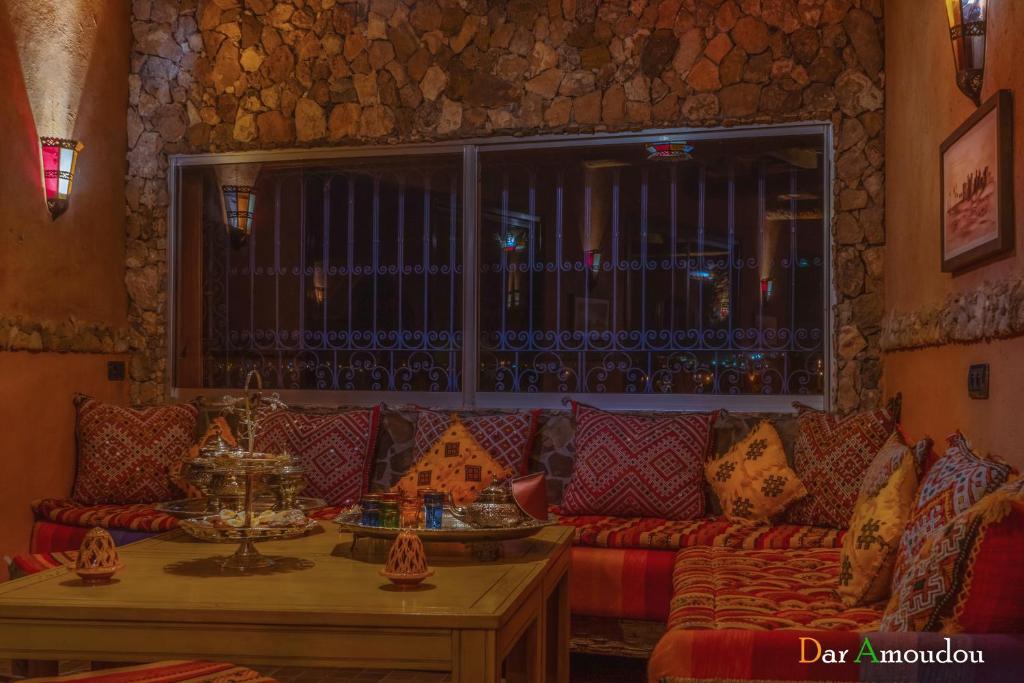 a living room with a red couch and a table at Dar Amoudou in Ouarzazate