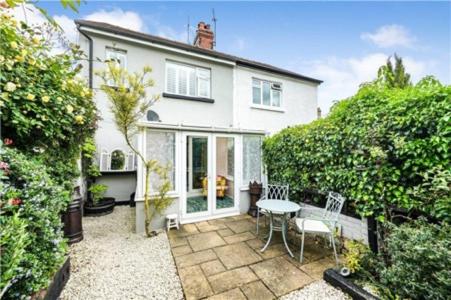 a white house with a patio with a table and chairs at St Mary's Cottage in Boston Spa