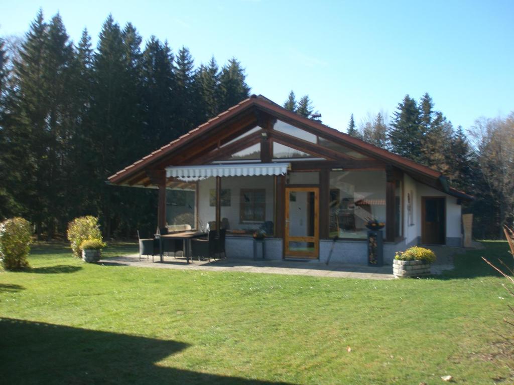 a small house with a picnic table in a yard at Ferienhaus Hütter in Neuschönau