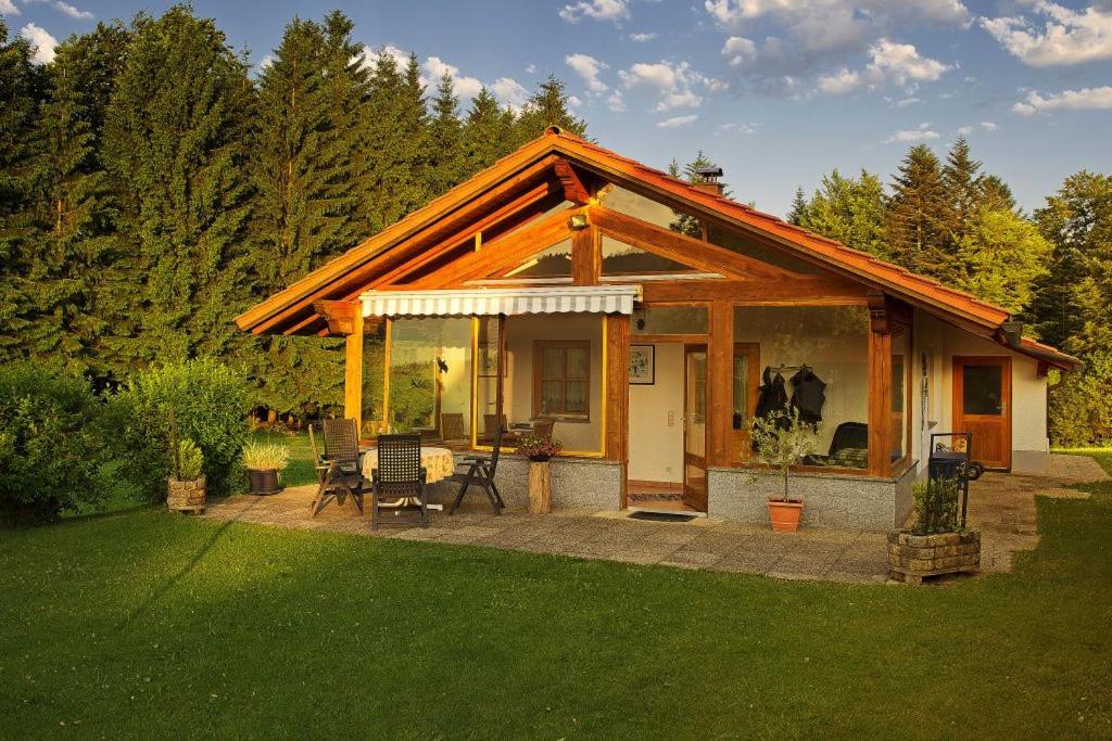 a small house with a patio in a yard at Ferienhaus Hütter in Neuschönau