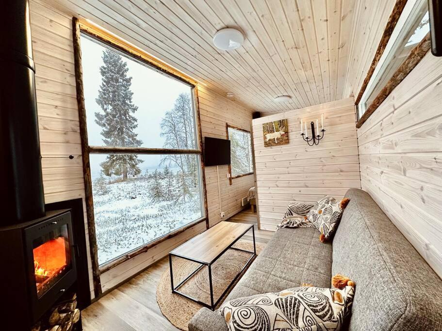 sala de estar con sofá y chimenea en Unique Cabin with Breathtaking Northern Light View, en Rovaniemi