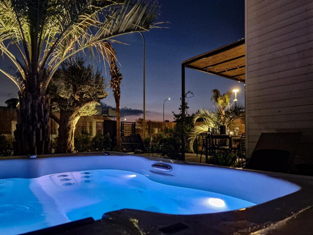 una gran bañera azul en un patio por la noche en Ortosalato Agricamping, en Torregrotta