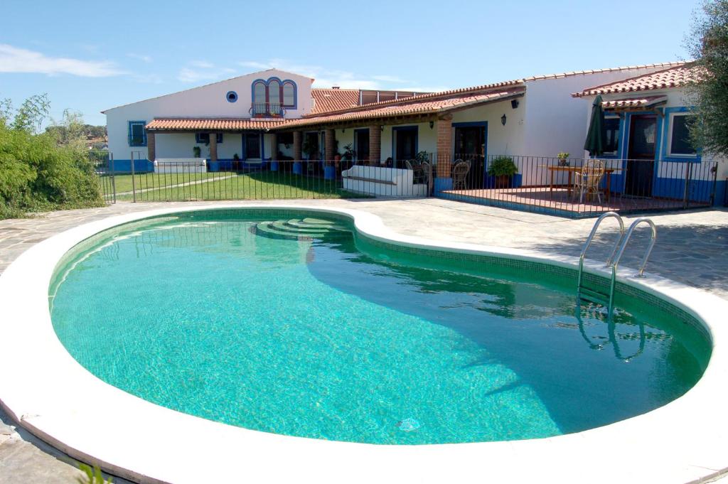 a swimming pool in front of a house at Monte do Laranjal in Monsaraz