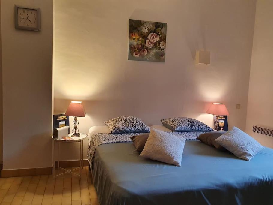 een slaapkamer met twee bedden met blauwe lakens en twee lampen bij Studio avec balcon vue sur le Tech in Amélie-les-Bains-Palalda