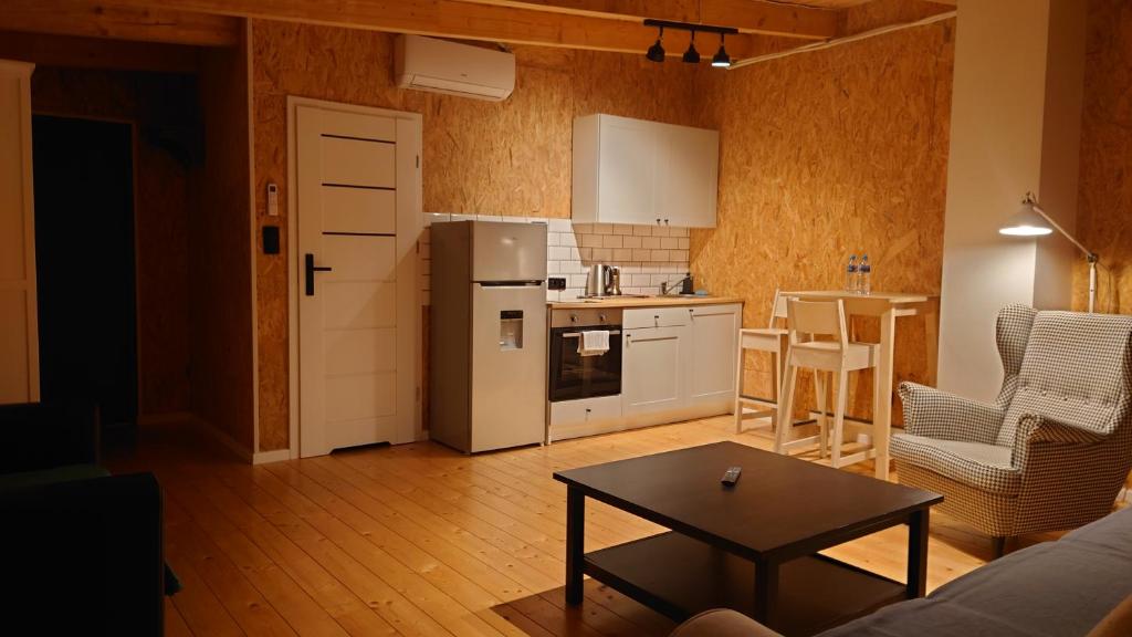 a kitchen with a refrigerator and a table in a room at Apartamenty STONEHENGE in Sosnowiec