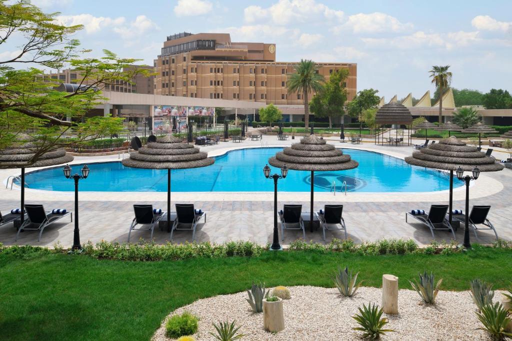 فندق إنتركونتننتال الرياض في الرياض: مسبح كبير مع كراسي ومظلات
