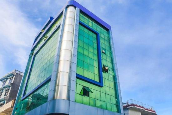 a building with green glass windows on it at Guru hotel and lodge in Itahari