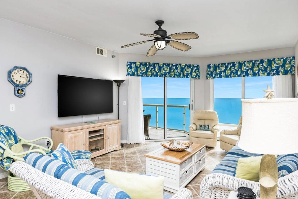 a living room with a flat screen tv and views of the ocean at The Beach Bounce in Pensacola Beach