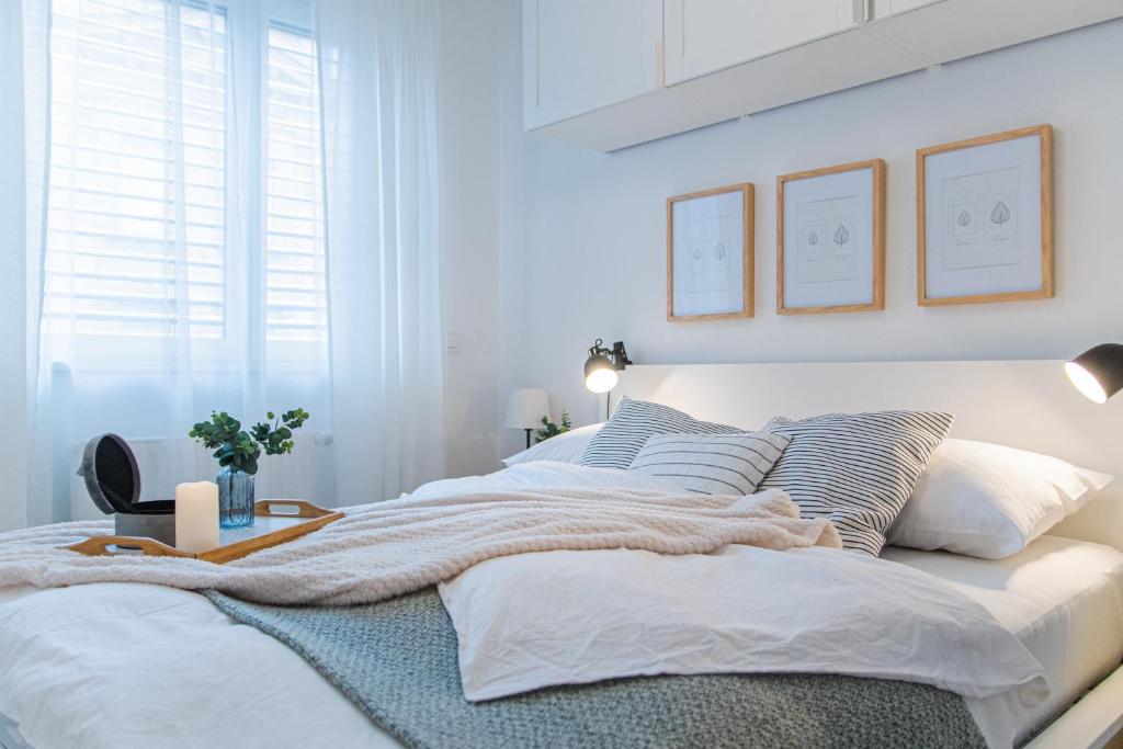 biała sypialnia z dużym łóżkiem z poduszkami w obiekcie Flexible SelfCheckIns 36 - Zagreb - Garage - Loggia - New - Luxury w Zagrzebiu