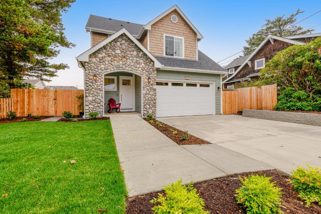 a house with a driveway and a fence at Seaside Ocean Getaway in Seaside