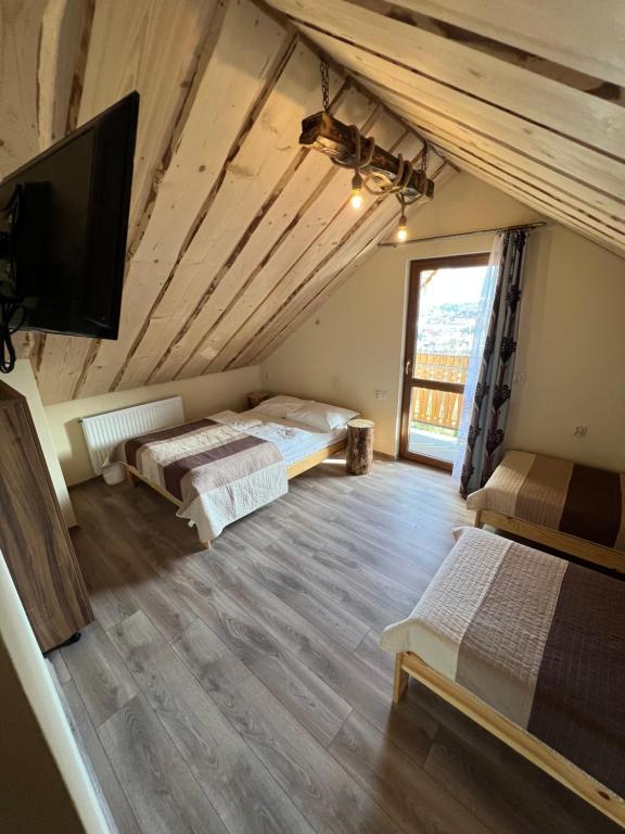 a room with two beds and a flat screen tv at Janickowa Ostoja in Zakopane