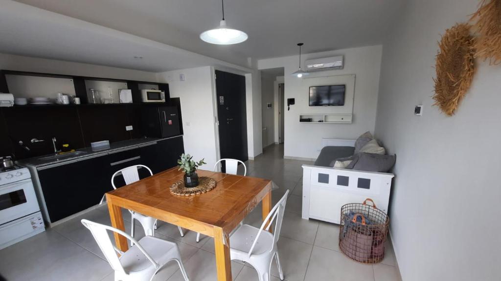 cocina y sala de estar con mesa de madera y sillas en Alquiler temporario en Tandil