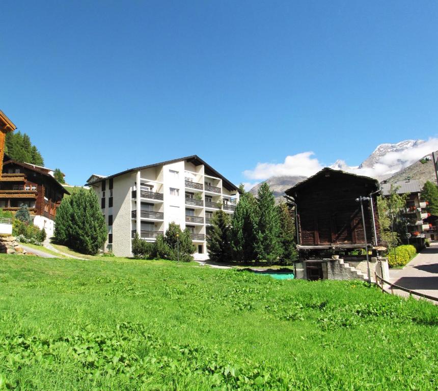 un complejo con césped verde frente a un edificio en Haus Cristal, en Saas-Fee