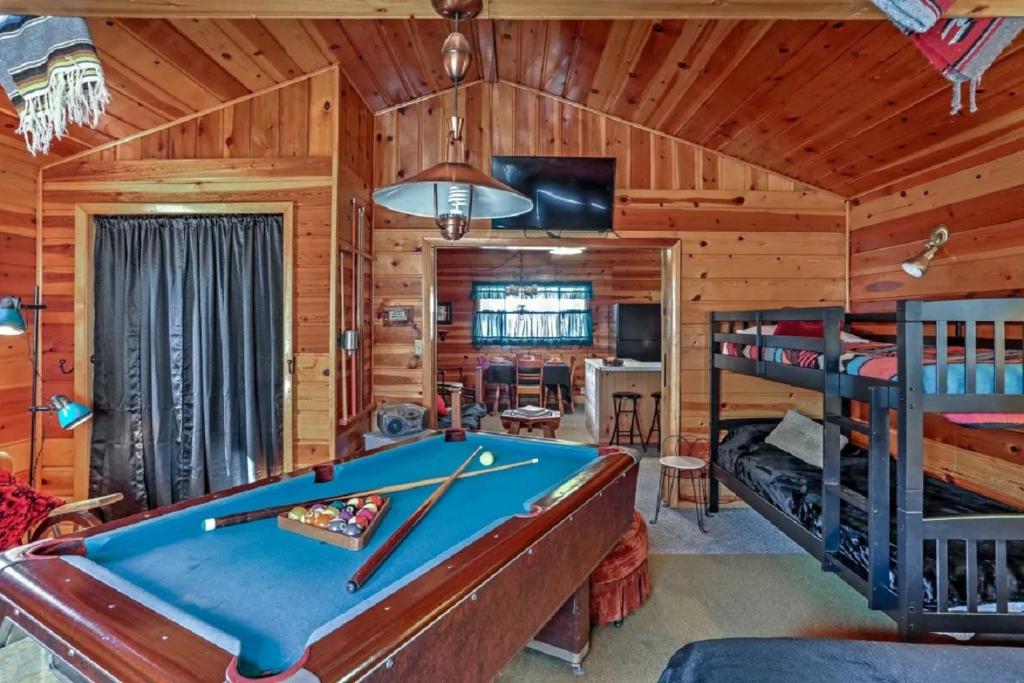 um quarto com uma mesa de bilhar e beliches em Happy Heart Bunkhouse em Pinetop-Lakeside