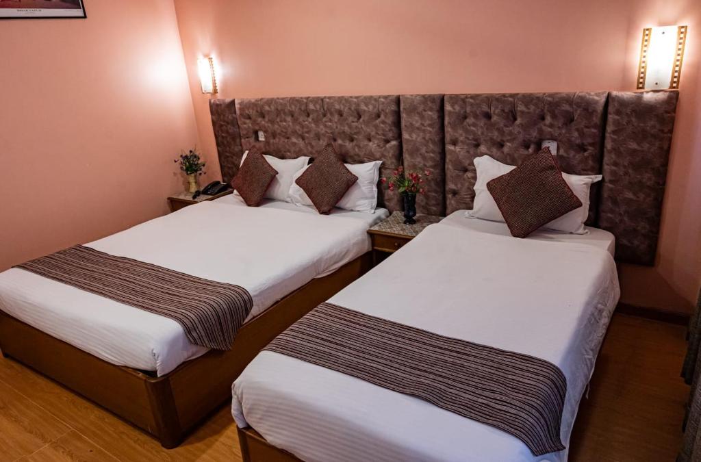 Postel nebo postele na pokoji v ubytování Kathmandu Prince Hotel