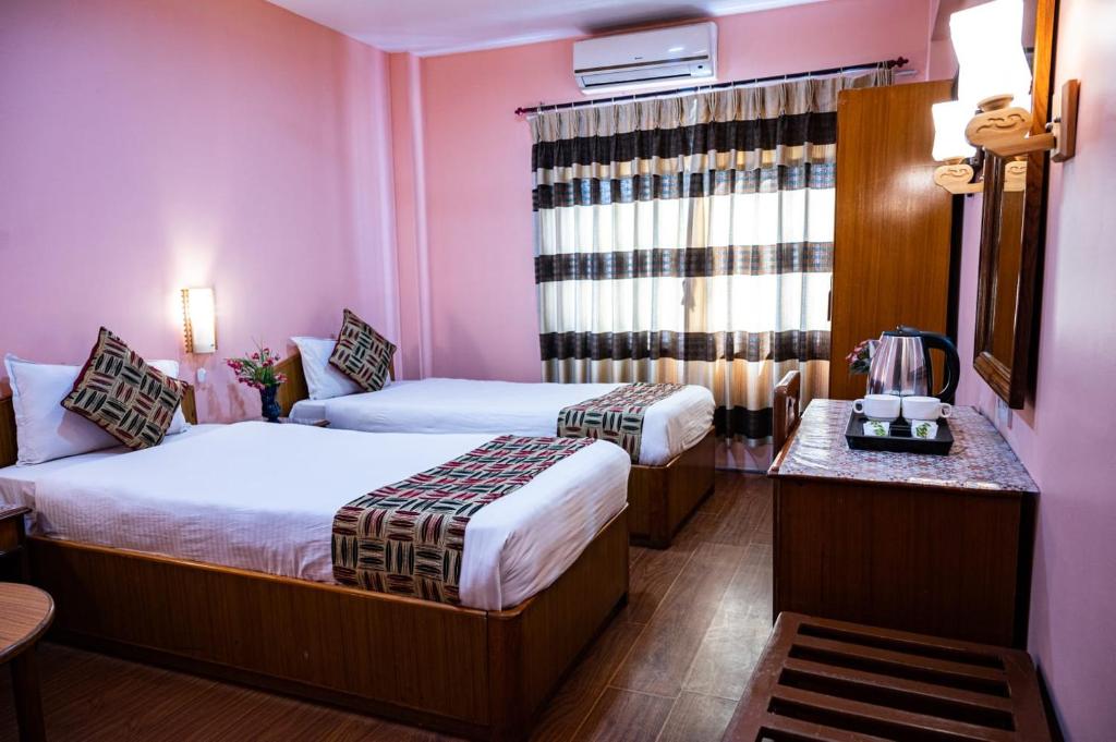 Postel nebo postele na pokoji v ubytování Kathmandu Prince Hotel