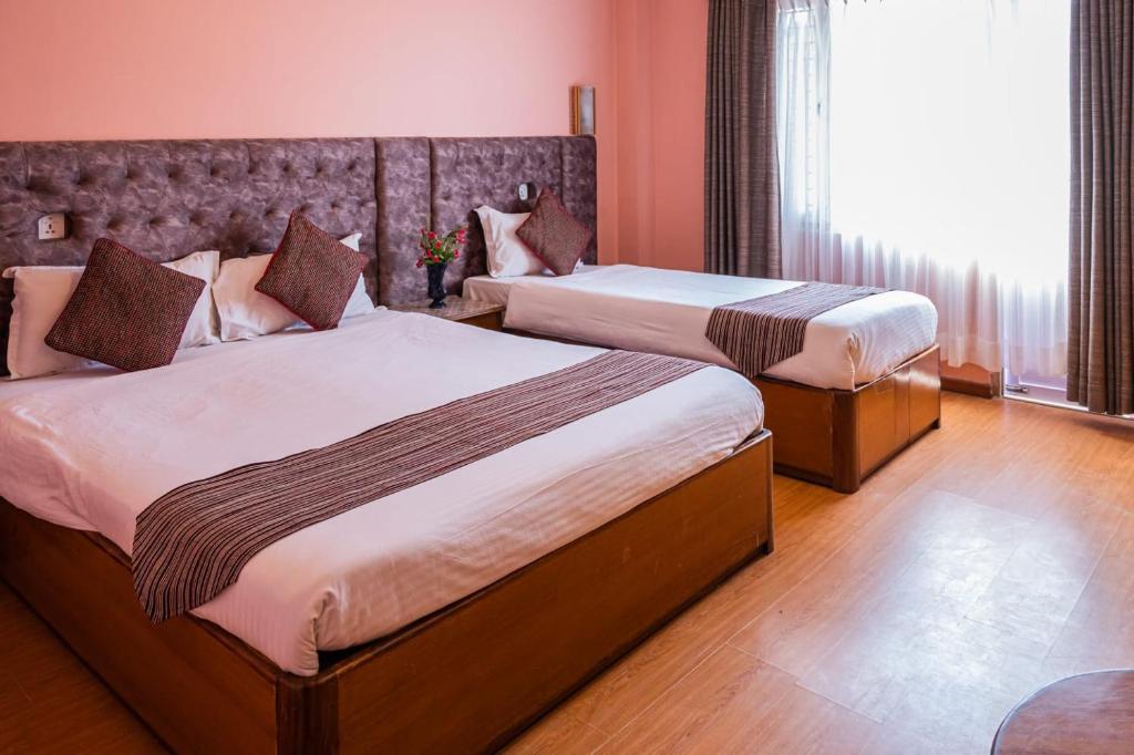 Postel nebo postele na pokoji v ubytování Kathmandu Prince Hotel