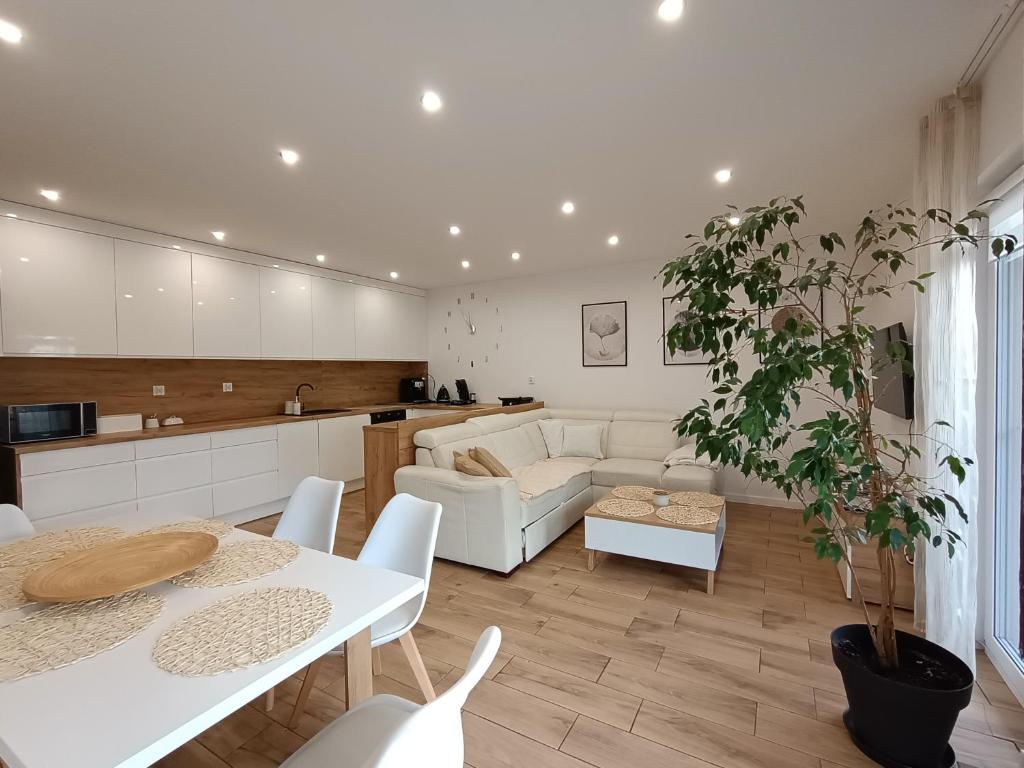 a living room with a white couch and a table at Apartament przy Kopalni Srebra in Tarnowskie Góry