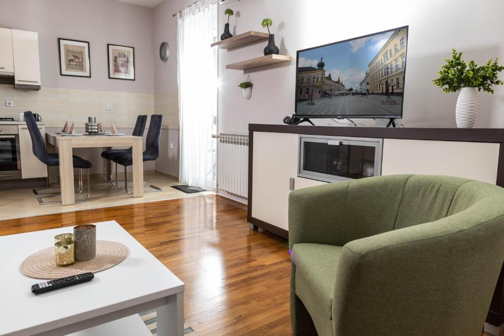 Apartman Gundulić في فينكوفسي: غرفة معيشة مع تلفزيون وغرفة طعام
