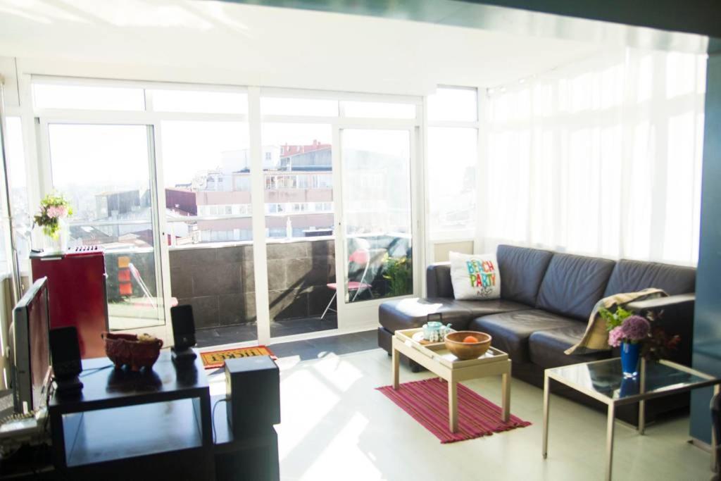 a living room with a couch and a large window at Plaza de España View with Terrace in A Coruña