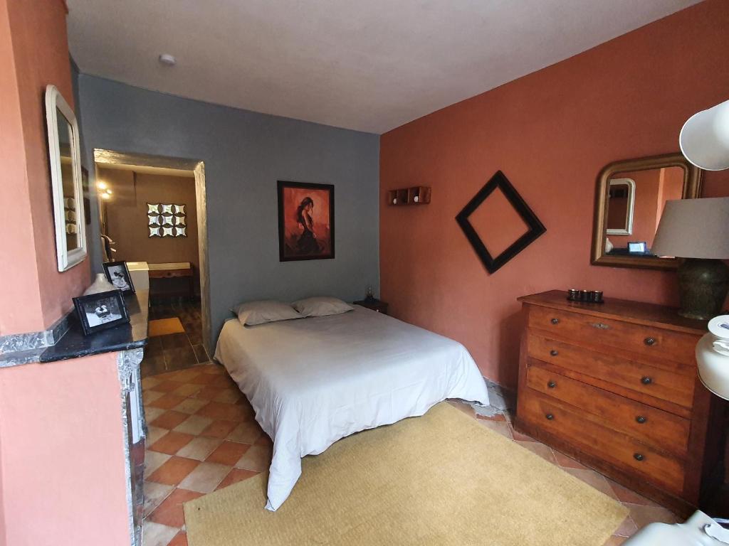 Schlafzimmer mit einem Bett, einer Kommode und einem Spiegel in der Unterkunft Très belle maison chaleureuse au coeur de Mirepoix in Mirepoix