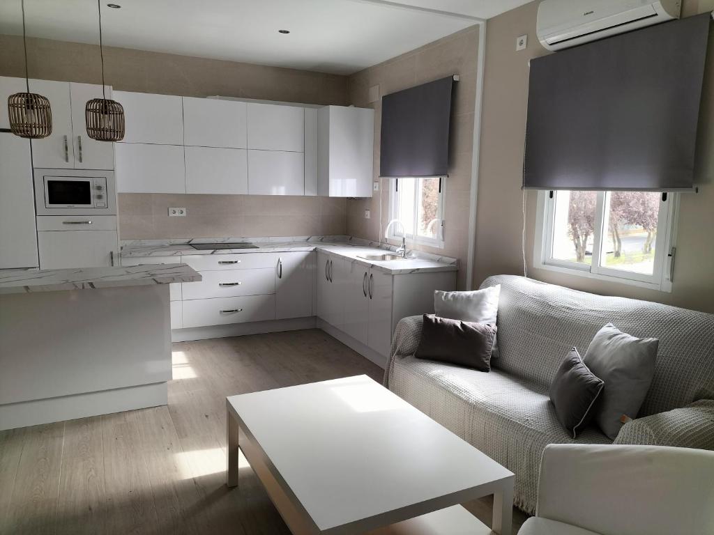 uma cozinha e sala de estar com um sofá e uma mesa em Apartamento zafra Cristina em Zafra