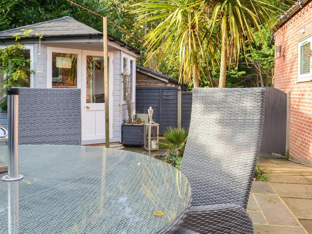 two chairs and a glass table in a backyard at Primrose Cottage - Uk41346 in Cromer