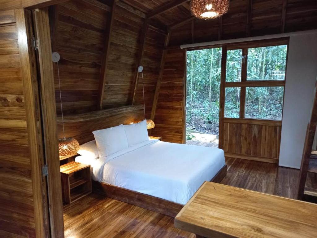 1 dormitorio con 1 cama en una cabaña de madera en ECO HOTEL RIO DE ORO, en San Rafael