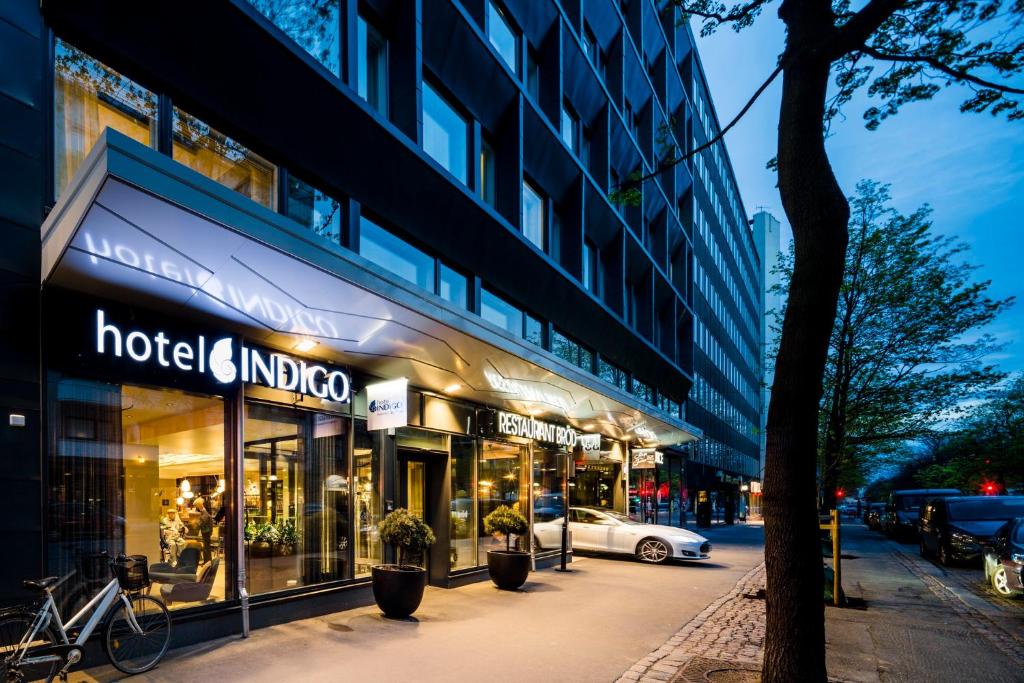 Hotel Indigo Helsinki-Boulevard, an IHG Hotel في هلسنكي: يوجد متجر هندي في الفندق في شارع المدينة في الليل