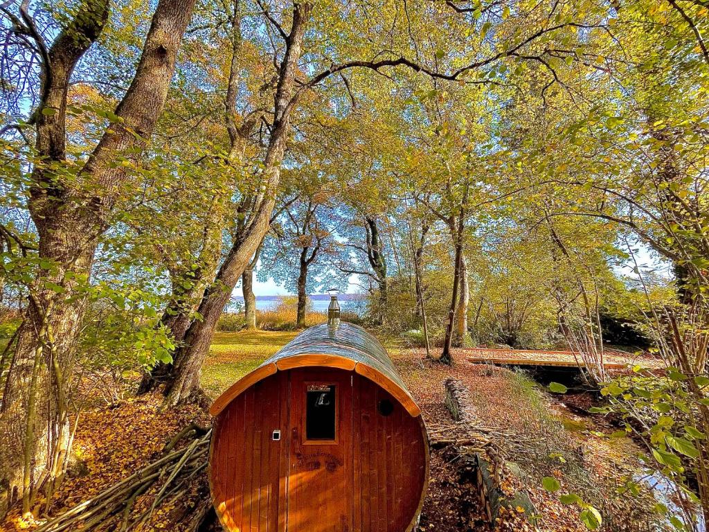 a wooden boat sitting in the middle of a forest at See-Chalet Riederau in Dießen am Ammersee