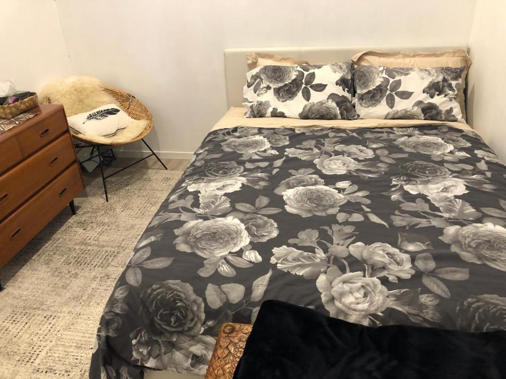 a bedroom with a bed with a black and white comforter at Cool Apartment, Central To Everything, share with 2x Bulldogs in Auckland