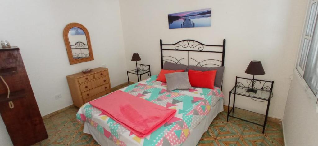 a bedroom with a bed and a dresser and a mirror at Casa Álamo Agaete in Agaete